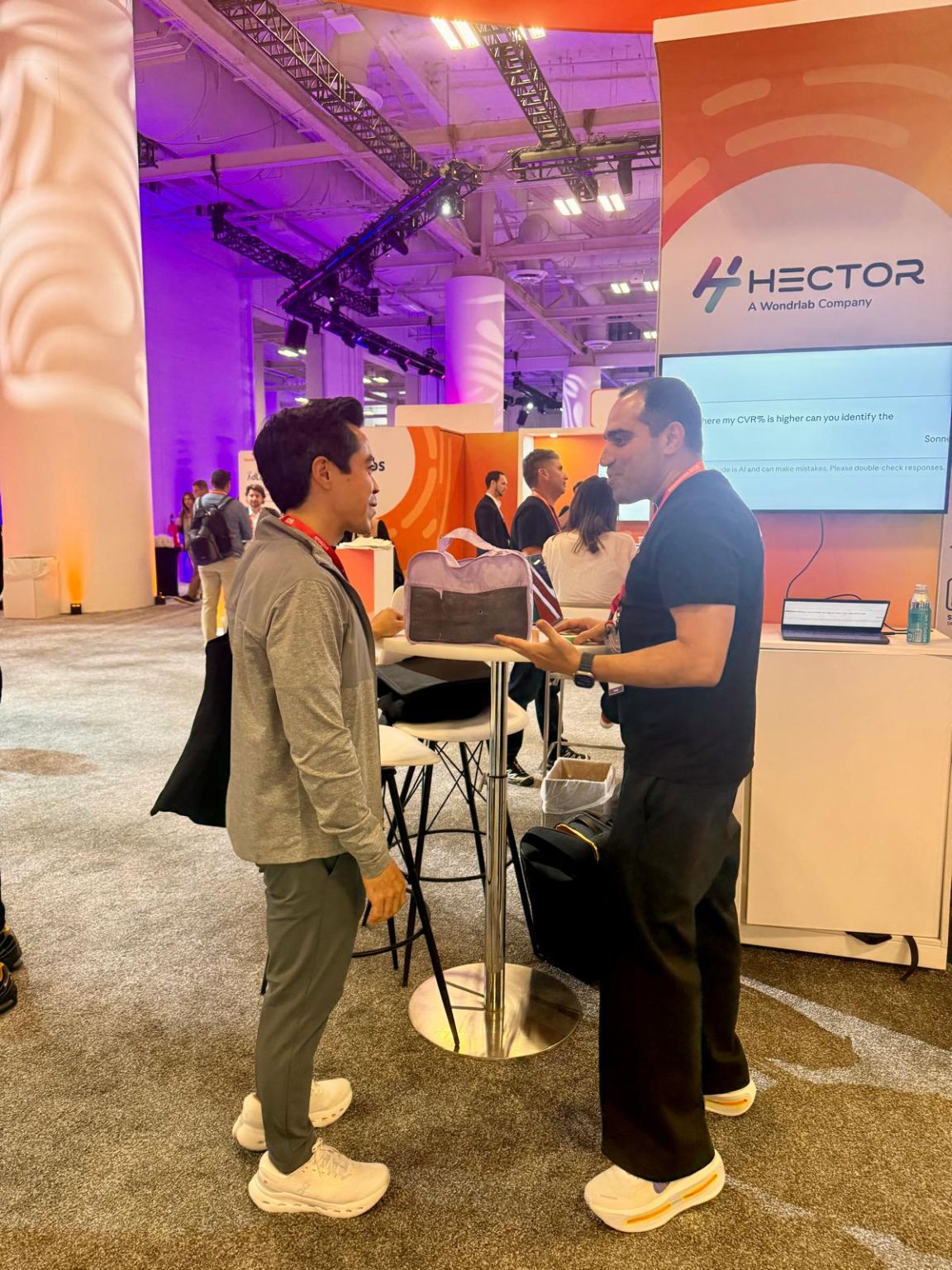 Hector Ai team talking with a visitor at the Hector Ai booth at Amazon Accelerate 2026